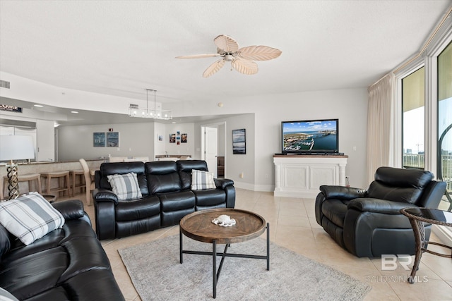 tiled living room with ceiling fan and a textured ceiling