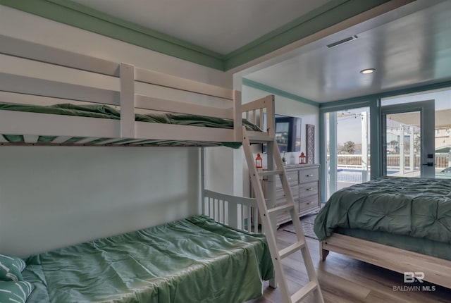bedroom with wood-type flooring and access to outside
