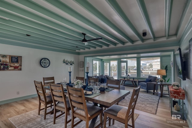 dining space featuring beamed ceiling, a healthy amount of sunlight, and light hardwood / wood-style floors