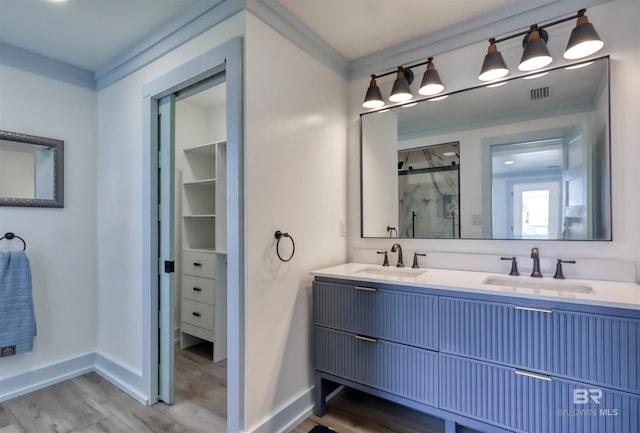 bathroom featuring hardwood / wood-style flooring, vanity, and a shower