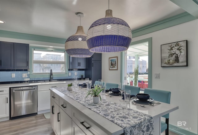 kitchen featuring dishwasher, pendant lighting, white cabinets, and backsplash