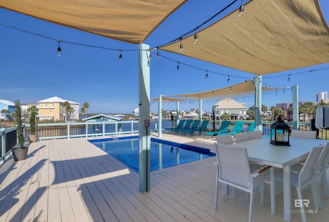 wooden terrace featuring a water view and a fenced in pool