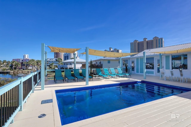 view of pool featuring a water view and a patio