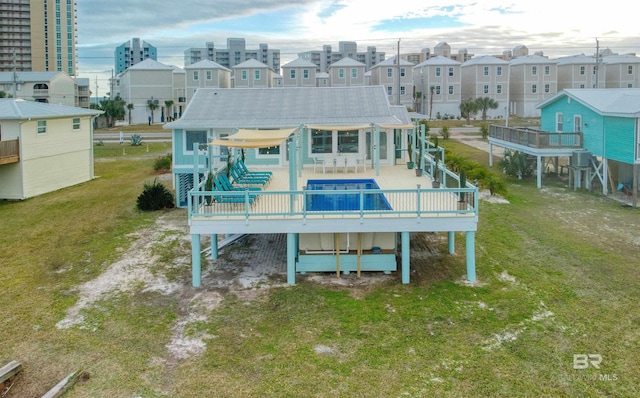 rear view of property with a deck and a lawn