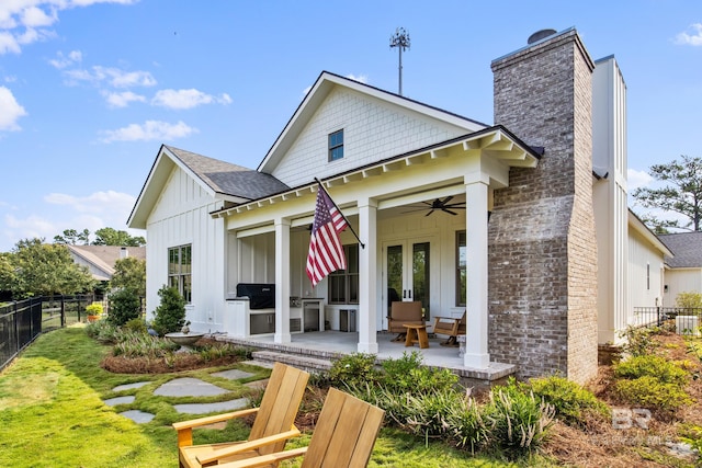 rear view of property with french doors, ceiling fan, a yard, and a patio area