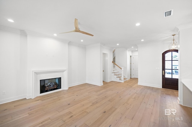 unfurnished living room featuring light hardwood / wood-style flooring, ceiling fan, and ornamental molding