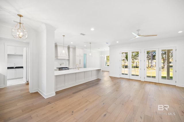 interior space with ceiling fan, light hardwood / wood-style flooring, ornamental molding, and sink