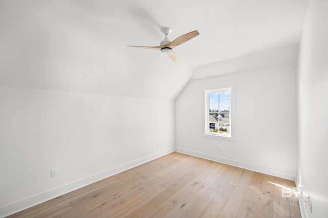 additional living space with light hardwood / wood-style floors, vaulted ceiling, and ceiling fan