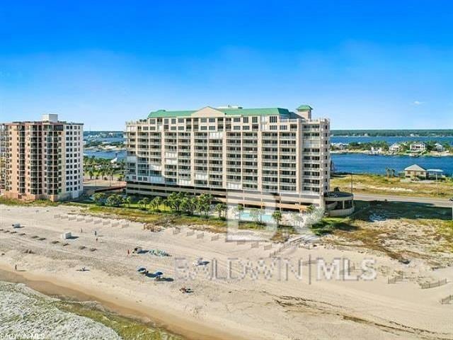 view of building exterior with a water view and a beach view