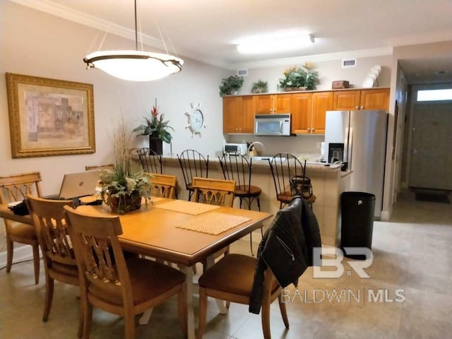 tiled dining area featuring crown molding