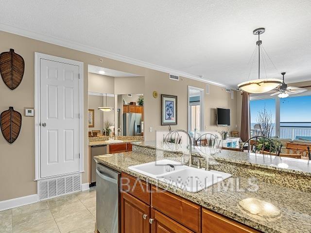 kitchen with ceiling fan, appliances with stainless steel finishes, light stone counters, and pendant lighting