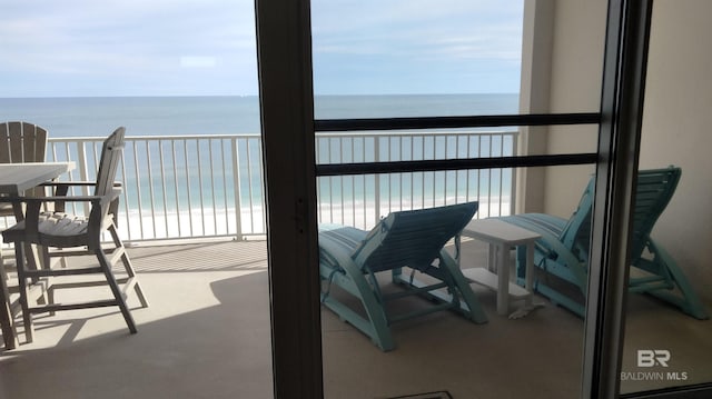 balcony featuring a beach view and a water view