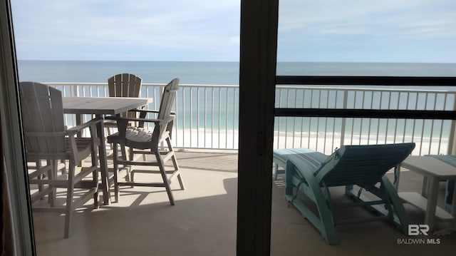 balcony featuring a view of the beach and a water view