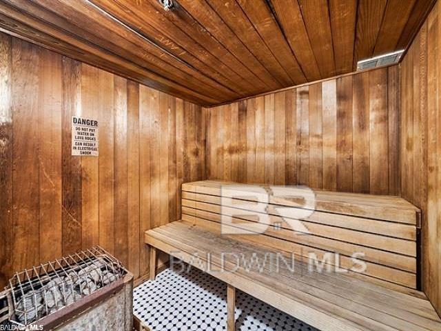 view of sauna / steam room featuring wooden ceiling and wood walls