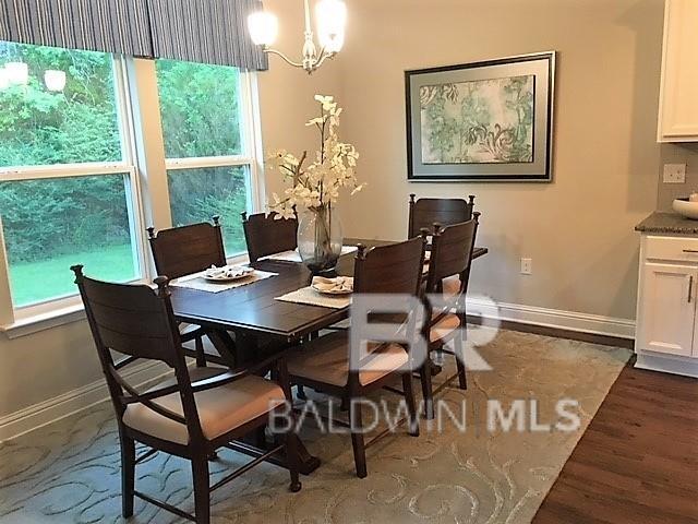 dining room featuring dark hardwood / wood-style flooring and an inviting chandelier