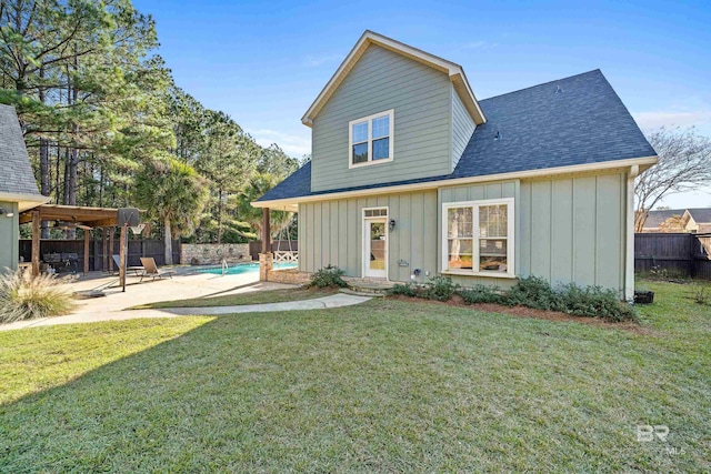 back of house featuring a patio, a fenced in pool, and a lawn