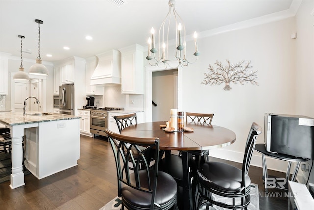 dining area with dark hardwood / wood-style flooring, ornamental molding, sink, and an inviting chandelier