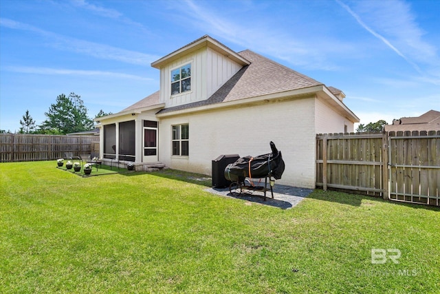 back of property with a yard and a sunroom