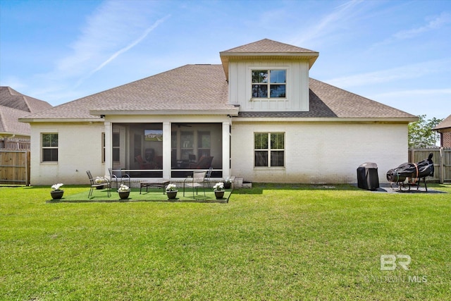 back of house with a sunroom, a fire pit, and a lawn