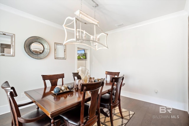 dining room featuring crown molding, dark hardwood / wood-style floors, and a notable chandelier