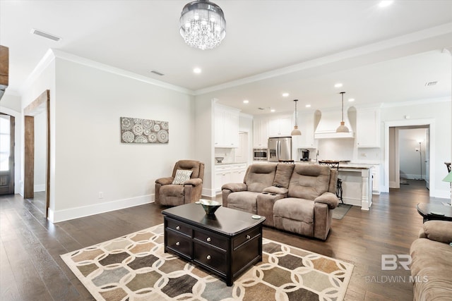 living room with ornamental molding, dark wood-type flooring, and a chandelier