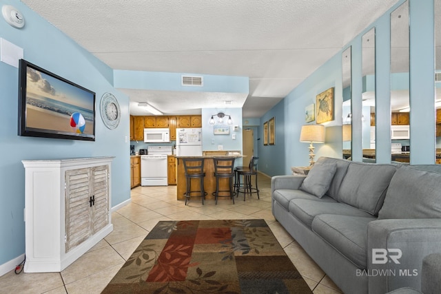 living room featuring a textured ceiling and light tile patterned flooring