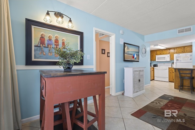 tiled dining area with a textured ceiling