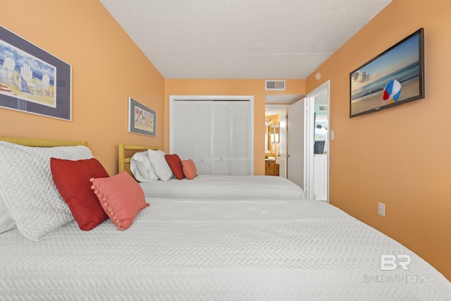 bedroom with a textured ceiling, connected bathroom, and a closet