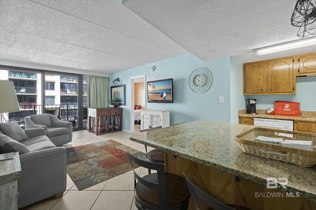 kitchen featuring dishwasher, light tile patterned flooring, and a textured ceiling