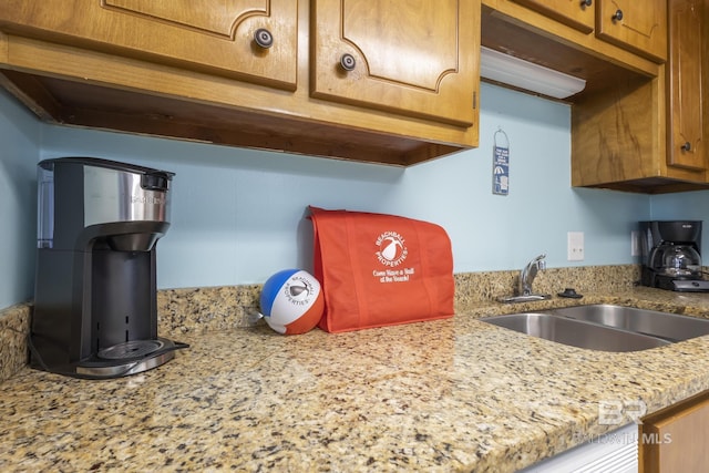 kitchen featuring light stone countertops and sink