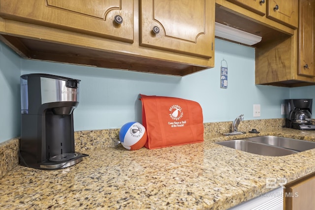 kitchen featuring light stone countertops and sink