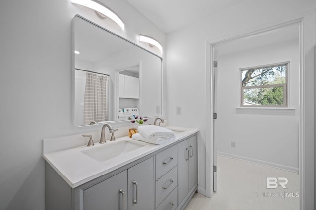 bathroom featuring a sink, baseboards, and double vanity