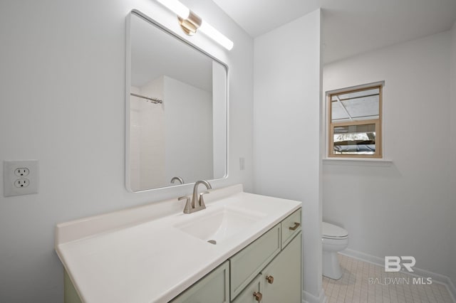 bathroom with baseboards, toilet, and vanity