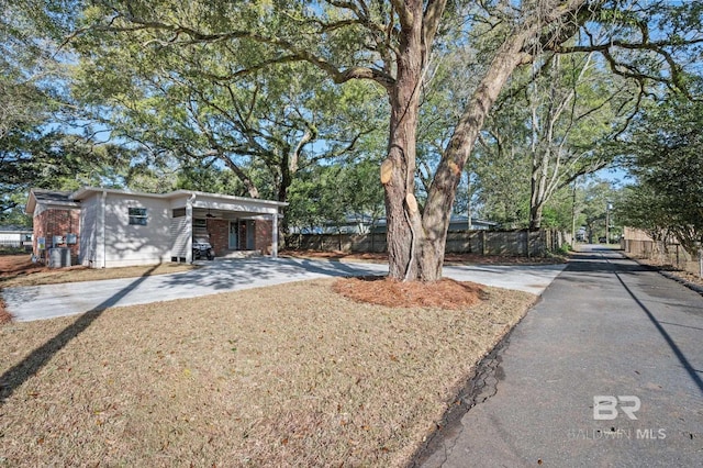 view of yard with driveway and fence