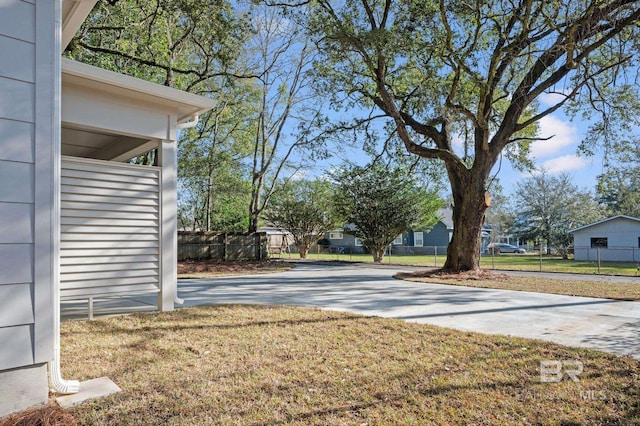 view of yard with fence and driveway