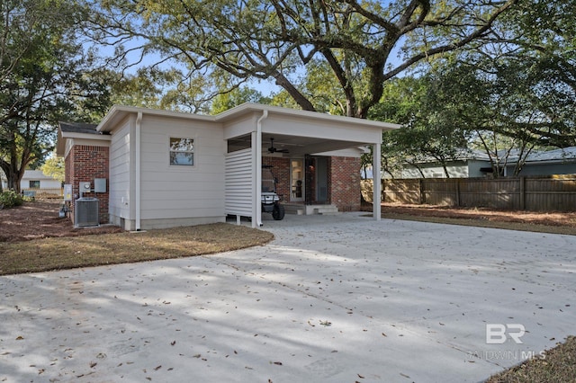 view of side of property with brick siding, entry steps, central AC, and fence