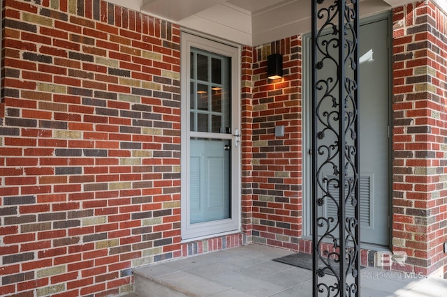 doorway to property with brick siding