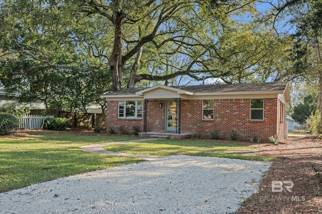 view of front of house featuring a front lawn, fence, and brick siding