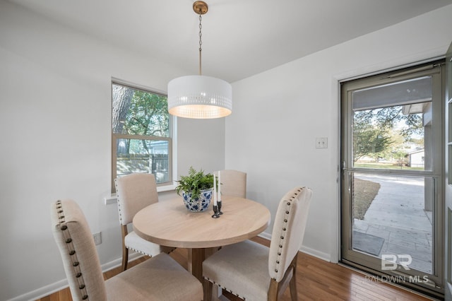 dining area with a wealth of natural light, baseboards, and wood finished floors