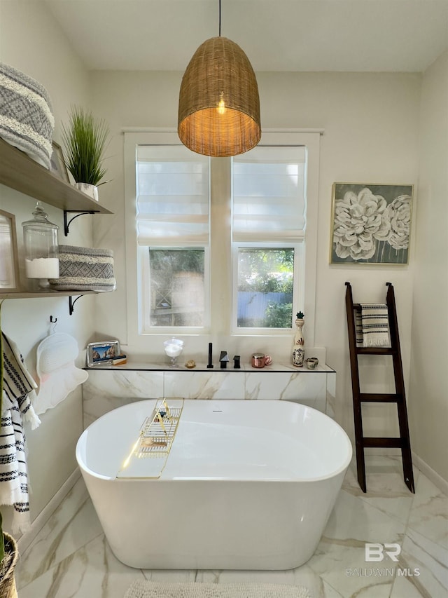 900 Hand Ave, Bay Minette, AL 36507 - bathroom featuring marble look tile flooring and a freestanding bath