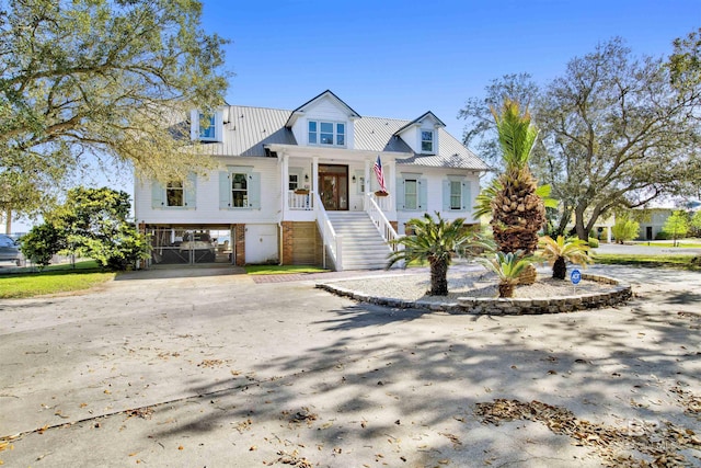 view of front of home featuring covered porch, stairway, a carport, metal roof, and driveway