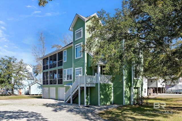 view of front of home featuring a garage and a sunroom