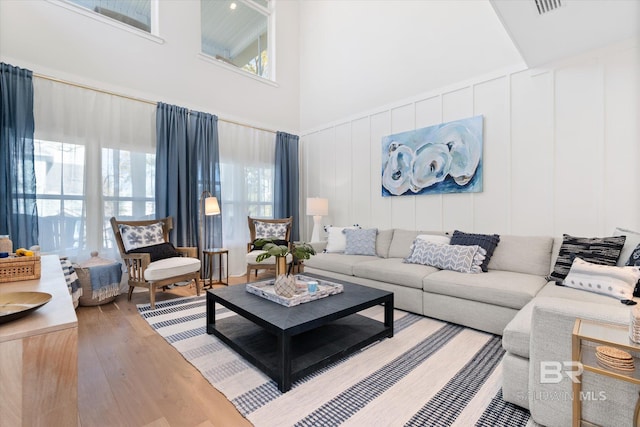 living room featuring a towering ceiling and hardwood / wood-style floors