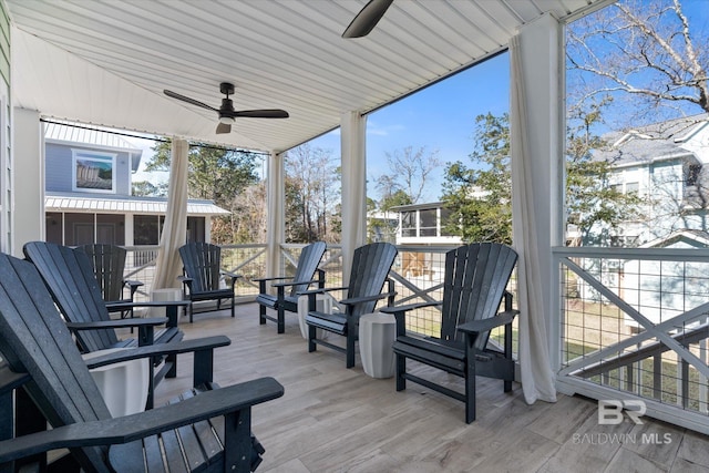 wooden terrace with ceiling fan and a sunroom