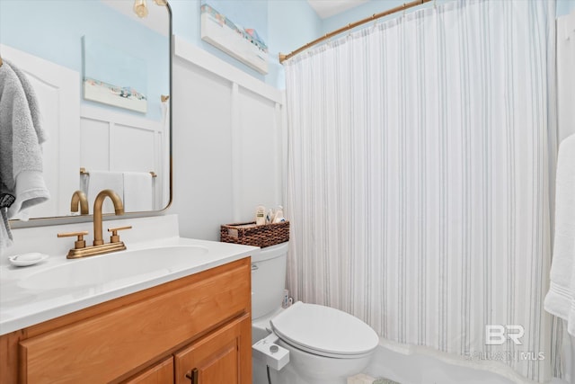 bathroom featuring curtained shower, toilet, and vanity