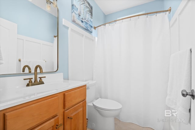 bathroom with toilet, vanity, and tile patterned floors