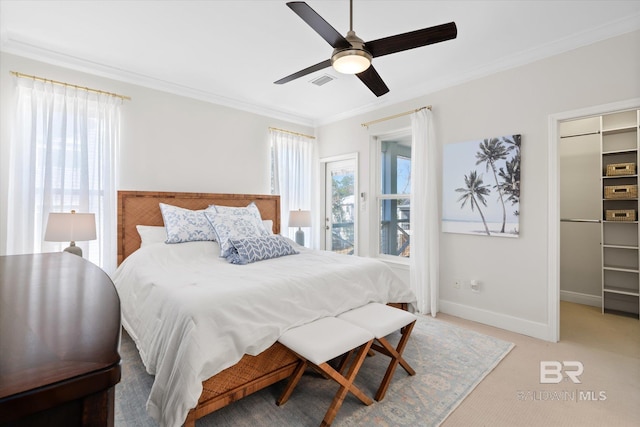 carpeted bedroom with ceiling fan, ornamental molding, and a closet