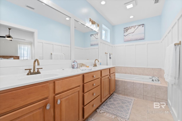 bathroom featuring ceiling fan, tiled tub, tile patterned floors, and vanity