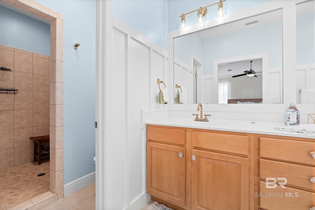 bathroom featuring ceiling fan, vanity, a tile shower, and tile patterned flooring