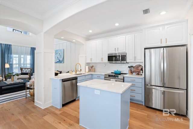 kitchen featuring sink, white cabinetry, appliances with stainless steel finishes, and a kitchen island